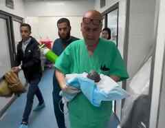Médico lleva en brazos a bebé que murió en Gaza