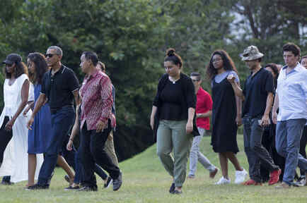 Barack y Michelle Obama paseando con sus hijas