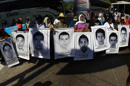 Relatives of the 43 missing students from Ayotzinapa Teacher Training College hold portraits of the students during a demonstration in Acapulco, Guerrero