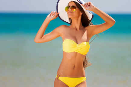 Mujer en la playa con un bikini amarillo