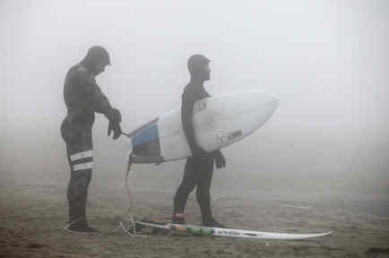 surfistas en la playa en invierno