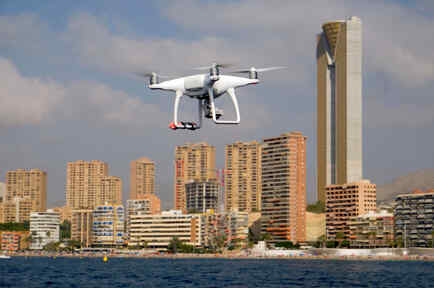 A drone, equipped with a camera used by police for surveillance tasks, flies in front of Poniente beach in Benidorm