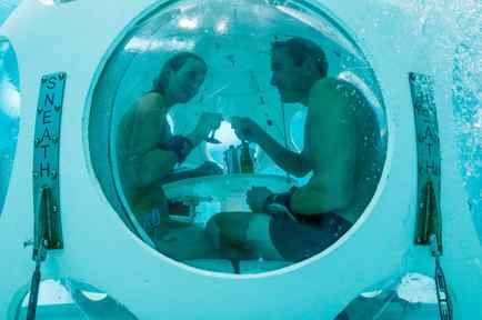 Belgians Florence Lutje Spelberg and Nicolas Mouchart drink champagne while sitting inside "The Pearl", a spheric dining room placed 5 metres underwater in the NEMO33 diving center in Brussels