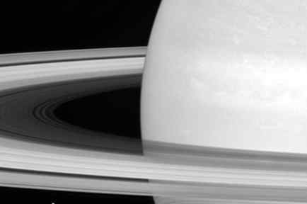 Esta foto sin fecha de la NASA muestra una de las lunas de Saturno, Mimas, empequeñecida por los anillos del planeta. 