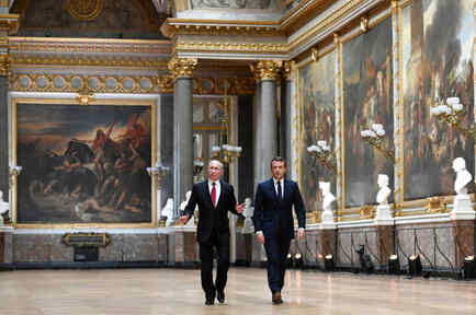 El presidente francés, Emmanuel Macron (derecha), y su homólogo ruso, Vladimir Putin, caminan por la Galería de las Batallas en el Palacio de Versailles antes de ofrecer una rueda de prensa conjunta este 29 de mayo. 