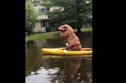 Una persona disfrazada de dinosaurio se pasea en kayak por las inundaciones causadas por el mal tiempo en Midland, Michigan