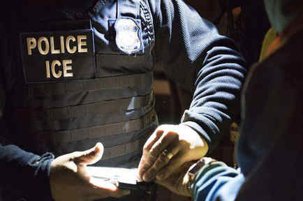 Agente de ICE toma huellas de un inmigrante