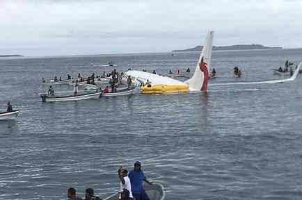 Pescadores locales ayudan a los tripulantes de un avión de la aerolínea Air Niugini a salir después de que se estrellara. 