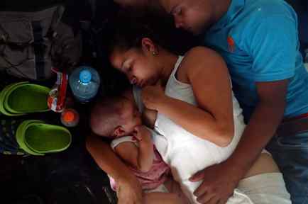 Una mujer migrante, parte de la primera caravana migrante, amamanta a su bebé mientras descansa este martes en un campamento improvisado en Juchitán, México.
