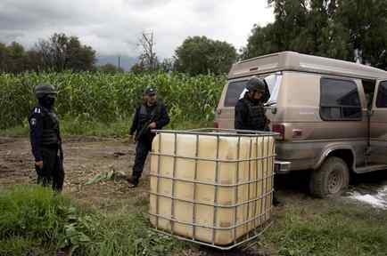 La policía mexicana resguarda un vehículo abandonado que había sido utilizado para transportar gasolina robada en San Bartolome Hueyapan, Tepeaca