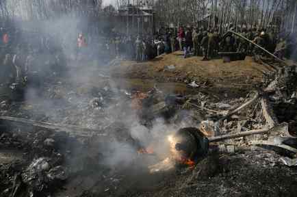 Aldeanos de Cachemira y soldados del ejército indio se reúnen cerca de los restos de un helicóptero indio