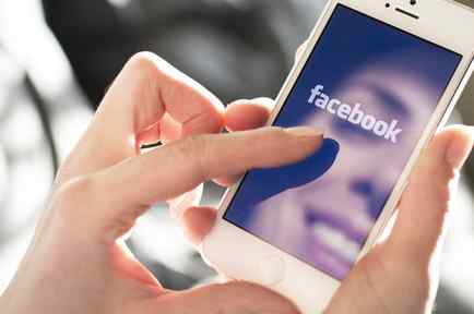 manos de mujer con celular entrando a Facebok
