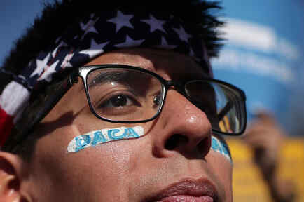 Hombre latino con el rostro pintado con la leyenda DACA