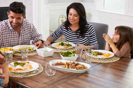 Familia hispana compartiendo una comida en la mesa