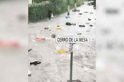 Torrente arrastra a varias personas por una calle inundada