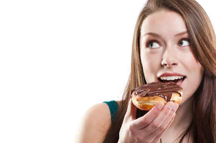 Mujer comiendo una dona de chocolate