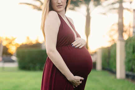 Mujer embarazada posa en un jardín