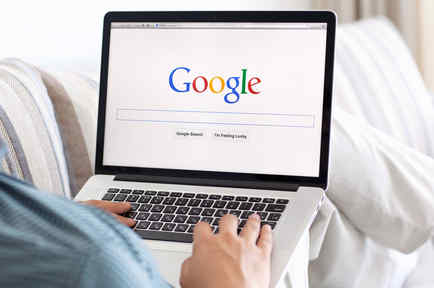 Hombre en un sofá navegando el sitio de Google