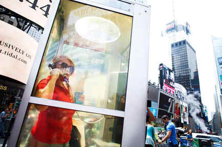 Una mujer utiliza una de las cabinas instaladas en Times Square, que narran historias de los inmigrantes de la ciudad. 