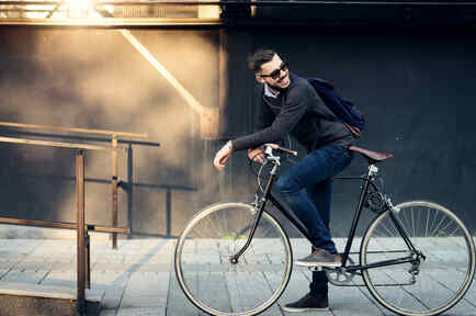 Hombre joven yendo en bicicleta al trabajo