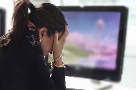Mujer estresada frente a una computadora