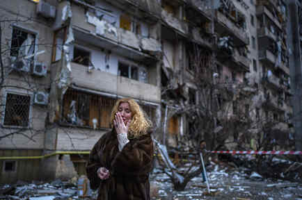 Una ciudadana ucraniana llora cerca de su casa tras un ataque con cohetes, el viernes 25 de febrero de 2022, en Kiev, Ucrania.