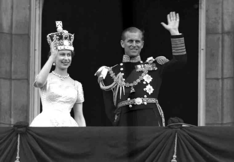 En esta foto del 2 de junio de 1953, la reina Isabel II de Inglaterra y su esposo, el duque de Edimburgo, saludan desde el balcón del Palacio de Buckingham en Londres tras la coronación de la reina en la Abadía de Westminster. 