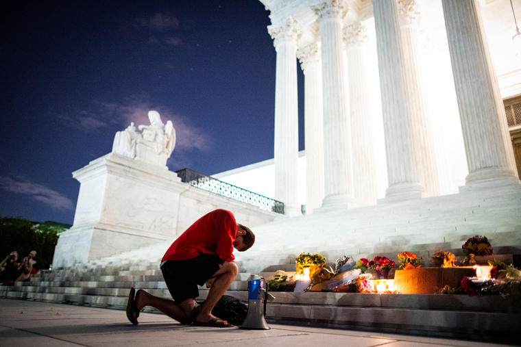 Un hombre se arrodilla frente a la Corte Suprema tras conocer la noticia del fallecimiento de Ginsburg.