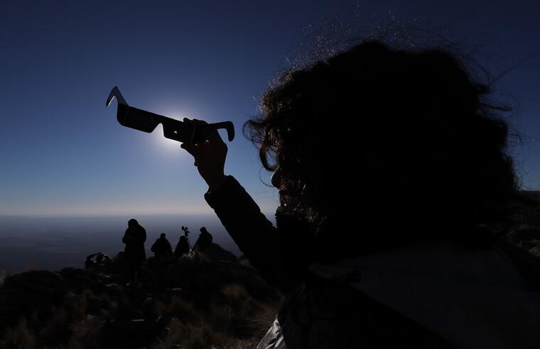 EcliUna persona mira sus anteojos especiales durante el Eclipse solar total, este martes, en la ciudad de Merlo, San Luis (Argentina). 