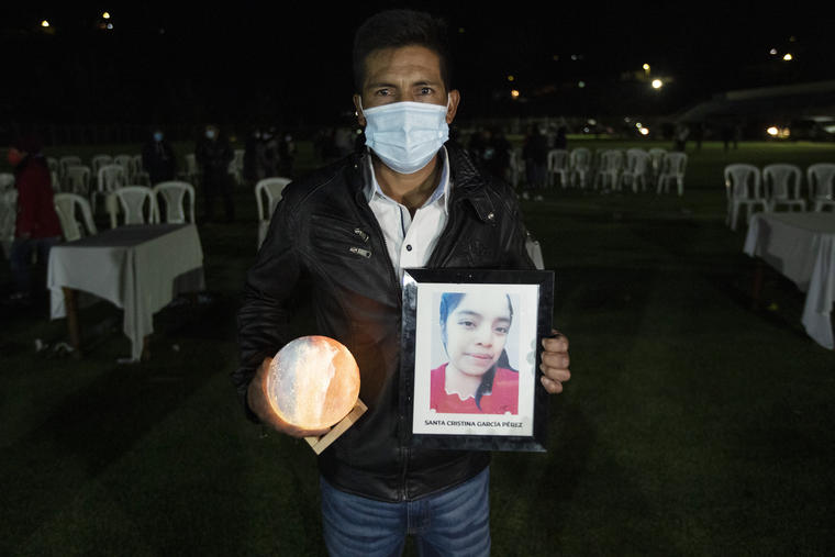 Ricardo García sostiene este viernes un retrato de su hija Santa Cristina García, asesinada en enero junto a otras 18 personas en Taumalipas, durante una misa conmemorativa en un estadio de fútbol en Comitancillo, Guatemala. 