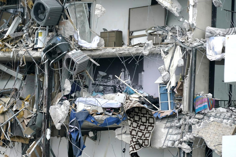 Pertenencias de residentes del condominio Champlain Towers cuelgan entre escombros tras el colapso parcial, el jueves 24 de junio de 2021, en Surfside, Florida.