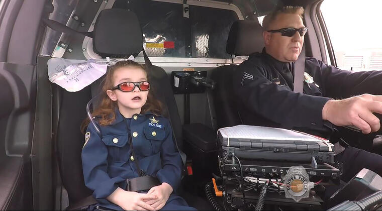 Olivia Gant, de 6 años, viaja en una patrulla del departamento de policía de Denver