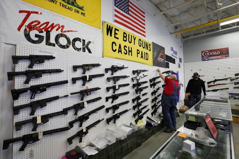 Trabajadores de una tienda de armas acomodan rifles AR-15 para su venta en Orem, Utah, el 14 de febrero de 2021. 