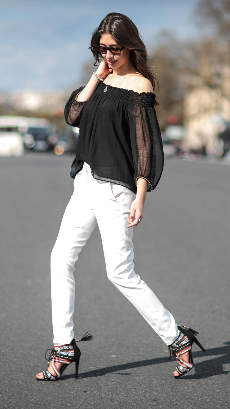 Mujer caminando en París con blusa de hombros descubiertos