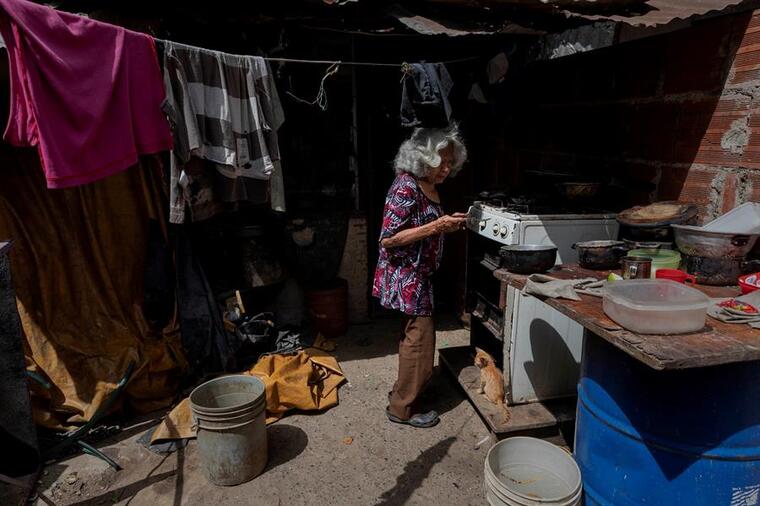  Una anciana cocinaba en su vivienda localizada en un terreno invadido en Caracas, el 11 de julio de 2020.