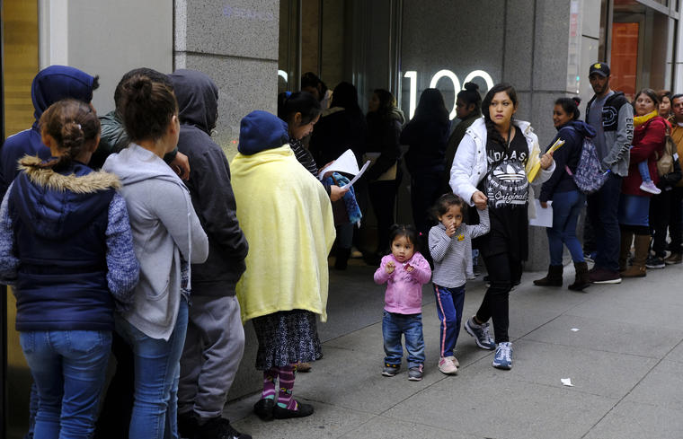 Cientos de personas hacen fila frente a una oficina de inmigración en San Francisco. 