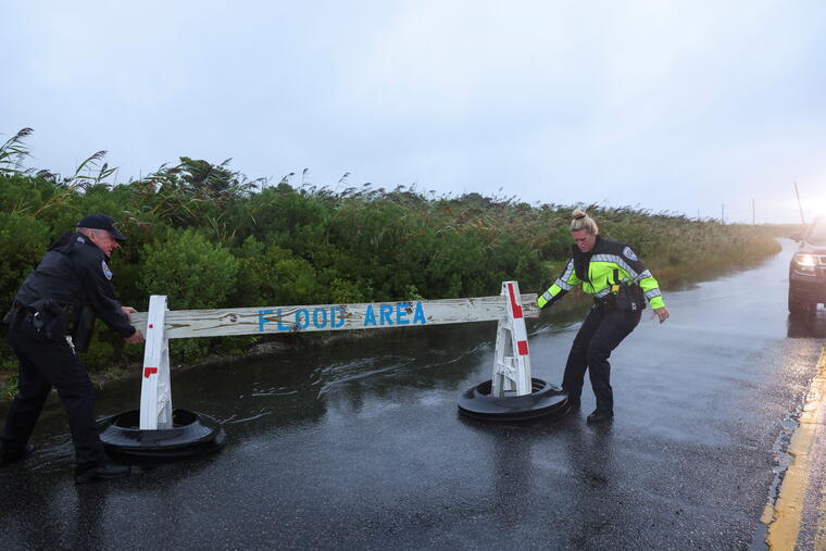 Oficiales de policía cierran una carretera por el riesgo de inundación ante la cercanía de la tormenta Henri en Long Island, el 22 de agosto de 2021.