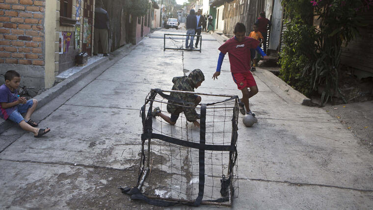 Niños juegan fútbol callejero en el barrio Progreso en Tegucigalpa, Honduras. Menores de ambos sexos practican con el entrenador Luis López como parte de un proyecto para alejarlos de la delincuencia mediante el fútbol. (AP Foto/Esteban Félix)