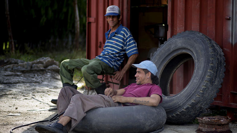 Un trabajador en un local de reparación de neumáticos descansa sobre una cámara de aire en La Habana, Cuba. Nuevas cifras muestran que las exportaciones estadounidenses a Cuba alcanzaron uno de sus puntos más bajos en una década el año pasado, un indicio de las barreras que enfrenta el comercio entre ambos países. (Foto: AP/Ramón Espinosa)