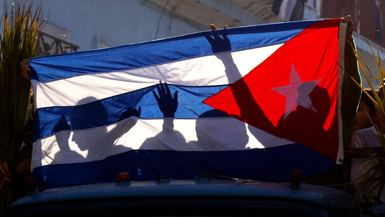 Siluetas se ven reflejadas en la bandera de Cuba. (Foto: AP/Ramon Espinosa)