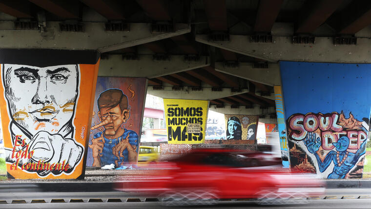 Un auto pasa a toda velocidad junto a un muro cubierto de grafitis en Bogotá. Se cree que hay más de 5.000 grafitis grandes en la capital colombiana, que lejos de combatir esa manifestación artística, la alienta. (Foto: AP/Fernando Vergara)