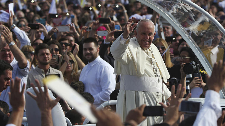 Pope Francis waves as he arrives to lead a mass in Asuncion
