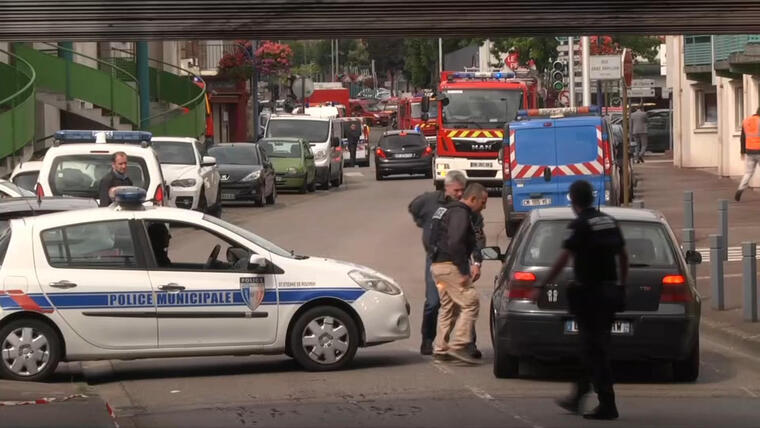 En esta imagen tomada de un video, policías hablan con un conductor tras cortar una calle durante una crisis de rehenes en Normandía, Francia, el 26 de julio de 2016. (BFM via AP)
