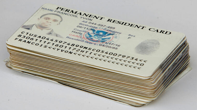 En la imagen de archivo aparecen varias tarjetas de residencia, conocidas en inglés como green cards. 