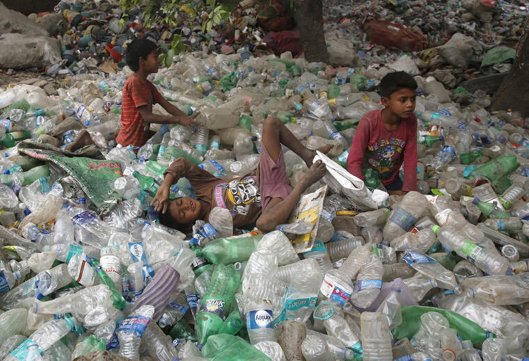Niños en India sobre un montón de botellas de plástico el pasado abril. 