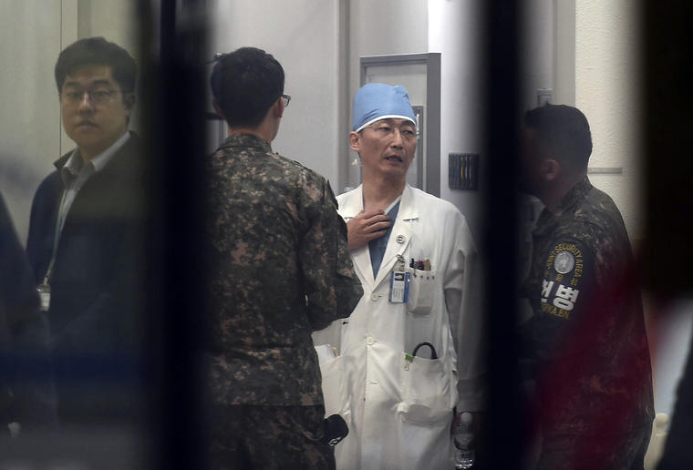 Soldados del ejército surcoreano hablan con un médico mientras se prepara para tratar a una persona no identificada, no vista, que se cree es un soldado norcoreano, en un hospital en Suwon, Corea del Sur, el lunes 13 de noviembre de 2017. Soldados norcore