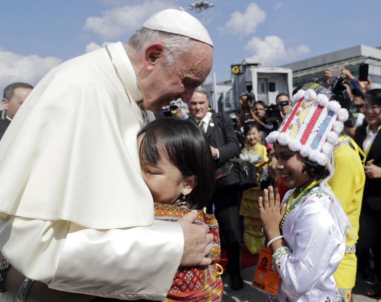 El papa Fanrcisco abraza a una niña en su llegada al aeropuerto de Yangon, Myanmar.