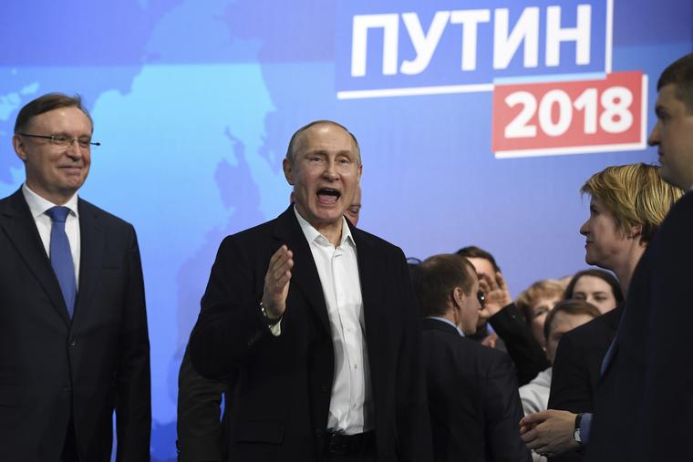 El presidente ruso Vladimir Putin, al centro, también candidato presidencial, habla en su sede de campaña en Moscú, Rusia, el domingo 18 de marzo de 2018.