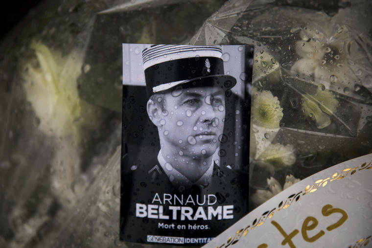 Una foto de  Arnaud Beltrame colocada sobre una homenaje de flores en Carcasona, Francia, este sábado.