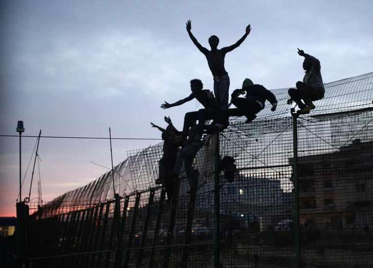 Inmigrantes subidos a la valla de la frontera española, en marzo de 2014.